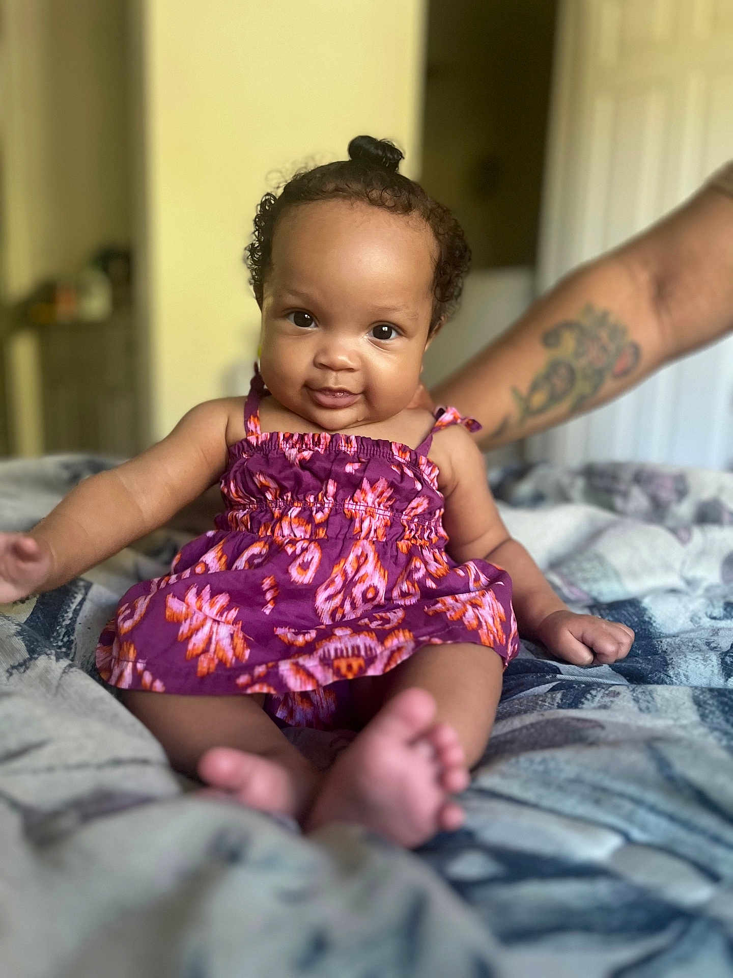 Lavender joined the competition — help win amazing prizes! baby, child, portrait, smile, dress, purple_dress, tattoo, bed, blanket, feet, hand, curly_hair, topknot, person, indoor, skin, cute, happy, support, warm_lighting