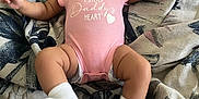 Lavender is registered to the contest to win money with this photo: baby, infant, smile, pink_onesie, bow, lying_down, blanket, happy, cute, child, sock, patterned_blanket, toddler, face, skin, small_child, indoors, portrait, person, young