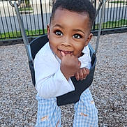 Jaden joined the competition — help win amazing prizes! child, toddler, swing, playground, wood_chips, smiling, happy, outdoor, clothing, pants, shirt, fence, residential_area, daylight, person, cute, play, fun, seat, young