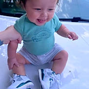 Kaleb is registered to the contest to win money with this photo: baby, bodypart, clothing, diaper, face, finger, footwear, hand, happy, head, outdoors, person, photography, portrait, shoe, shorts, sitting, sneaker, transportation, vehicle