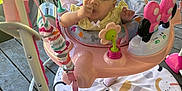 Aurora joined the competition — help win amazing prizes! activity_center, baby, child, clothing, colorful, curious, face, footwear, grass, hand, infant, jumper, outdoor, pink, play, porch, railing, sitting, toy, wooden_floor