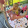 Aurora joined the competition — help win amazing prizes! baby, child, infant, jumper, toy, pink, outdoor, porch, grass, play, curious, sitting, face, hand, clothing, footwear, colorful, activity_center, railing, wooden_floor