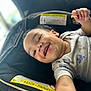 baby, child, smiling, car_seat, snack, hand, face, clothing, infant, messy, happy, portrait, closeup, indoor, seat, warning_label, cute, young_child, holding, expression