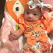 Aurora is registered to the contest to win money with this photo: baby, infant, girl, headband, bow, orange_clothing, floral_pattern, baby_seat, polka_dots, cartoon_animals, hearts, cute, portrait, indoor, child, smiling, expression, person, young_child, colorful