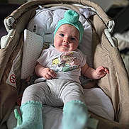 Khatalia participe au concours pour gagner de l'argent avec cette photo : baby, infant, turban, socks, baby_carrier, smile, face, clothing, white_shirt, gray_pants, indoor, soft_light, cute, child, person, portrait, relaxing, seat, comfort, toy