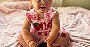 Isla joined the competition — help win amazing prizes! baby, child, infant, sitting, smiling, portrait, indoors, bedroom, bed, pink, dress, strawberry, bow, blonde_hair, blue_eyes, barefoot, toy, gadget, happy, furniture