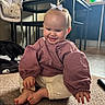 baby, barefoot, bow, cabinets, carpet, child, hair_bow, happy, high_chair, household, indoor, infant, kitchen, long_sleeves, pink_clothing, playpen, portrait, sitting, smiling, white_pants