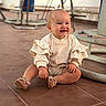 Isla is registered to the contest to win money with this photo: baby, blonde_hair, bow, child, daylight, dress, face, frills, furniture, happy, infant, outdoor, patio, person, photography, portrait, seated, shoes, smiling, tile_floor