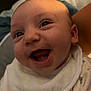 baby, cheerful, child, closeup, clothing, cute, face, happy, head, human, indoor, infant, newborn, patterned_outfit, person, portrait, skin, smiling, soft_lighting, white_bib