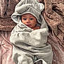 baby, towel, hood, elephant, blanket, soft, texture, cute, infant, smile, face, eyes, lying_down, wrapped, cozy, indoors, person, child, happy, plush