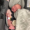 baby, infant, car_seat, blanket, pacifier, sleeping, straps, cozy, cloud_pattern, cute, child, indoor, soft_texture, pink_clothing, foot, head, face, peaceful, resting, safety