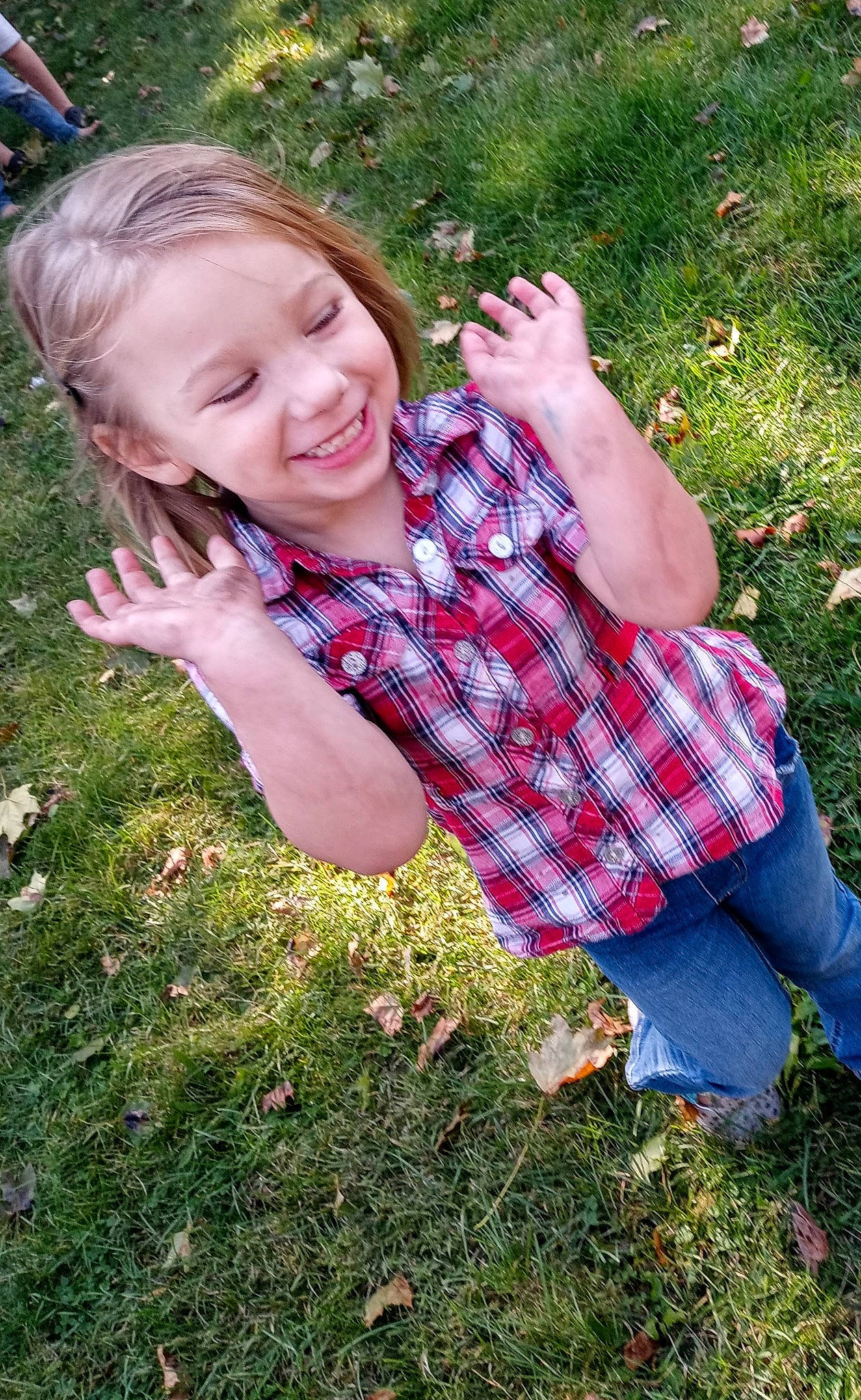 Arabella Grace is registered to the contest to win money with this photo: botany, finger, fun, gesture, grass, grass_family, grassland, groundcover, hand, happy, joy, lawn, leisure, meadow, people_in_nature, person, plaid, plant, smile, tartan