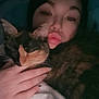 person, cat, calico_cat, hand, blanket, face, pout, sleeping, indoors, cozy, dark, closeup, snuggling, feline, pet, warm, comfort, nighttime, soft, intimate