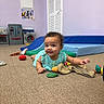 Kollyns joined the competition — help win amazing prizes! baby, blue_mattress, carpet, child, clothing, curly_hair, cute, floor, green_toy, happy, indoor, infant, lying_down, play_kitchen, playroom, red_toy, room, smiling, toys, young_child