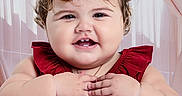 Amy Albert Sosa is registered to the contest to win money with this photo: baby, child, dress, red_dress, bows, curly_hair, smile, happy, portrait, hands, cute, indoors, curtains, pink_curtains, toddler, face, chubby_cheeks, cute_expression, person, young_child