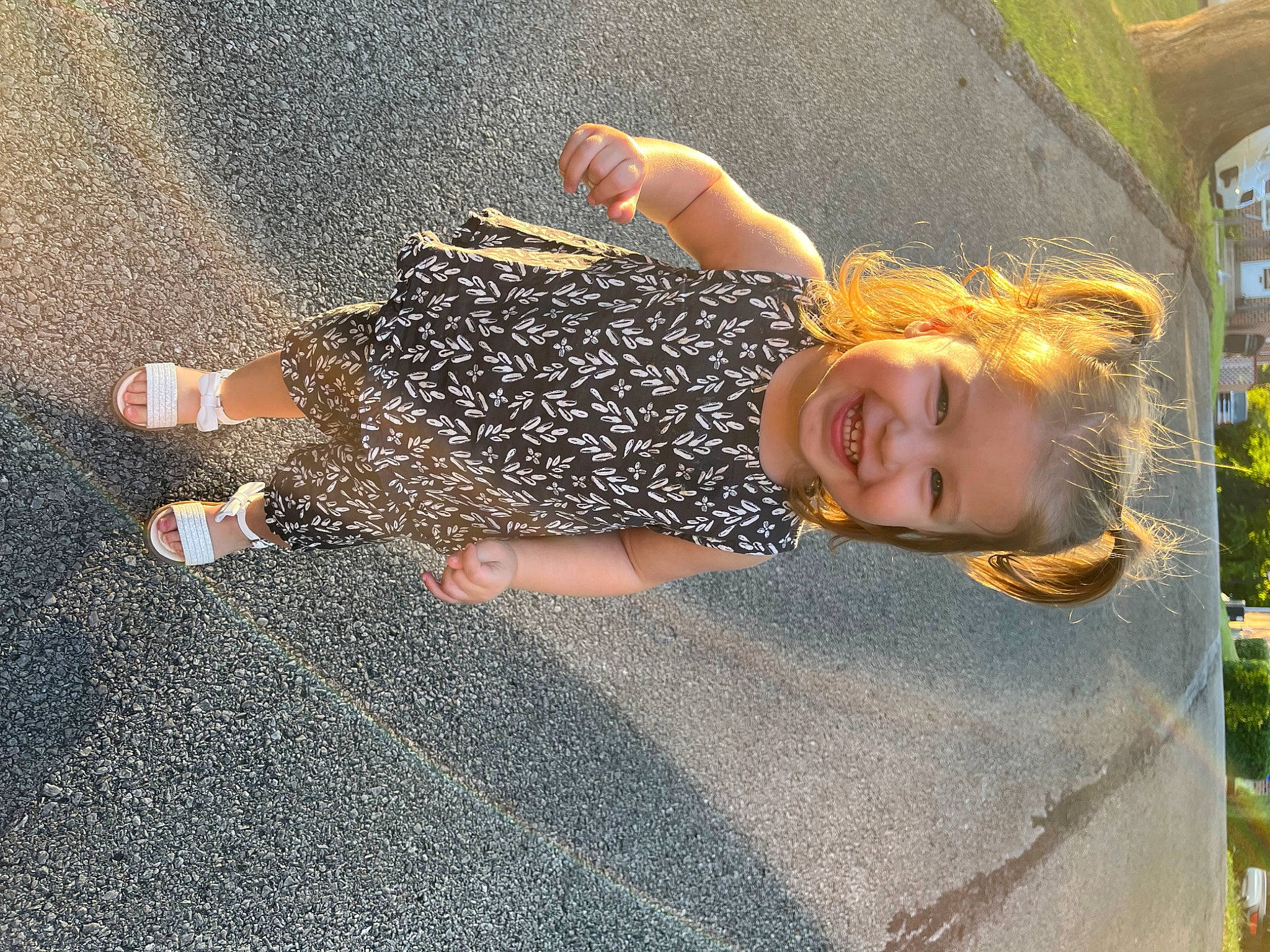 Briella is registered to the contest to win money with this photo: asphalt, barefoot, child, flooring, foot, fun, gesture, grass, human_leg, joy, leisure, pattern, people_in_nature, person, plant, road_surface, shadow, smile, tar, thigh