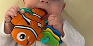 Nina participe au concours pour gagner de l'argent avec cette photo : baby, infant, child, teether, toy, clownfish, onesie, cute, chewing, hand, eyes, closeup, portrait, indoor, blanket, play, neutral_expression, grip, seat, skin