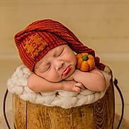 Cooper is registered to the contest to win money with this photo: baby, sleeping, orange_hat, knit_hat, pumpkin_patch, felt_pumpkin, wooden_bucket, fluffy_blanket, resting, cute, infant, portrait, cozy, soft_texture, newborn, peaceful, child, indoors, warm_colors, adorable