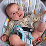 baby, infant, child, baby_seat, seatbelt, toy, sock, clothing, face, head, arm, leg, floor, pattern, fabric, comfort, indoor, cute, playful, curious