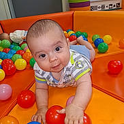Lylio a rejoint le concours — aidez-le/la à gagner de superbes lots ! baby, child, ball_pit, colorful, play_area, orange_cushion, plastic_balls, crawling, cute, indoor, toddler, fun, childcare, playtime, smiling, curious, small_hand, bright_colors, soft_padded, infant