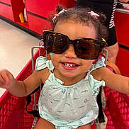 Peyton joined the competition — help win amazing prizes! toddler, child, shopping_cart, sunglasses, smile, happy, cute, clothing, store, retail, red, person, hair_bows, baby, face, indoor, casual, playful, seat, toy
