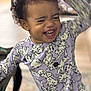 Peyton is registered to the contest to win money with this photo: child, toddler, laughing, pajamas, purple, dalmatian, dog_pattern, curly_hair, earrings, indoor, carpet, table, smiling, happy, person, clothing, cute, playful, expression, home