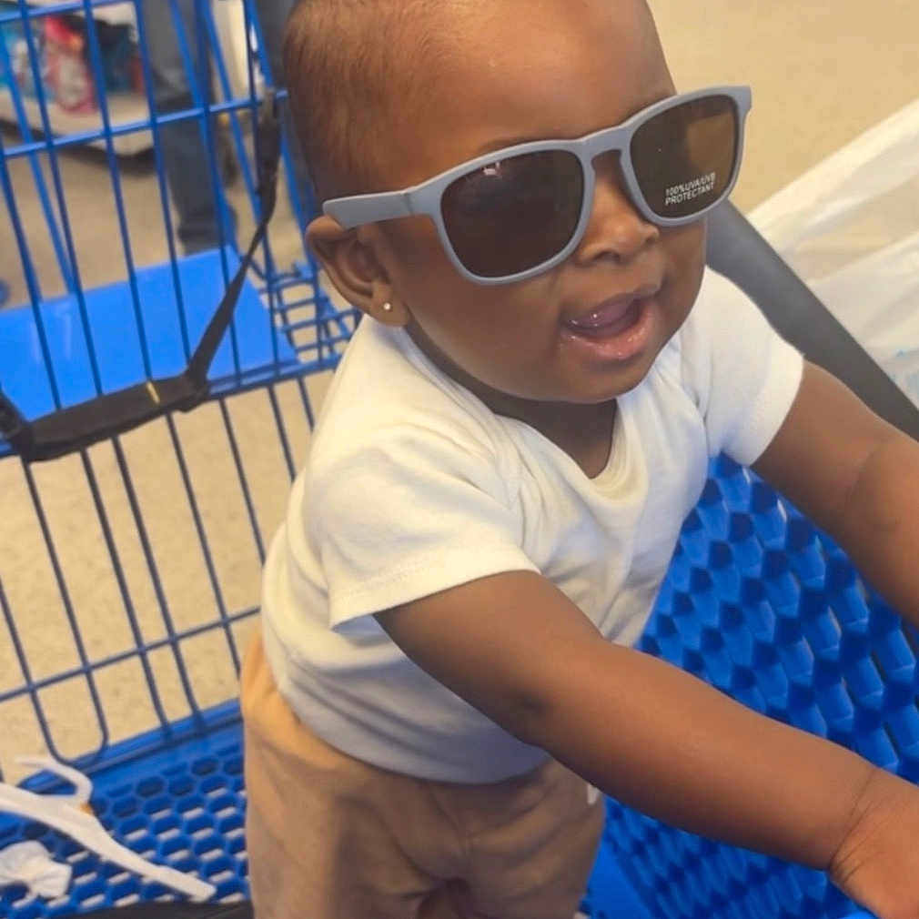 Dasaih is registered to the contest to win money with this photo: accessory, aisle, baby, blue, child, clothing, cute, earrings, floor, indoor, pants, person, retail, shopping, shopping_cart, smiling, standing, store, sunglasses, white_shirt
