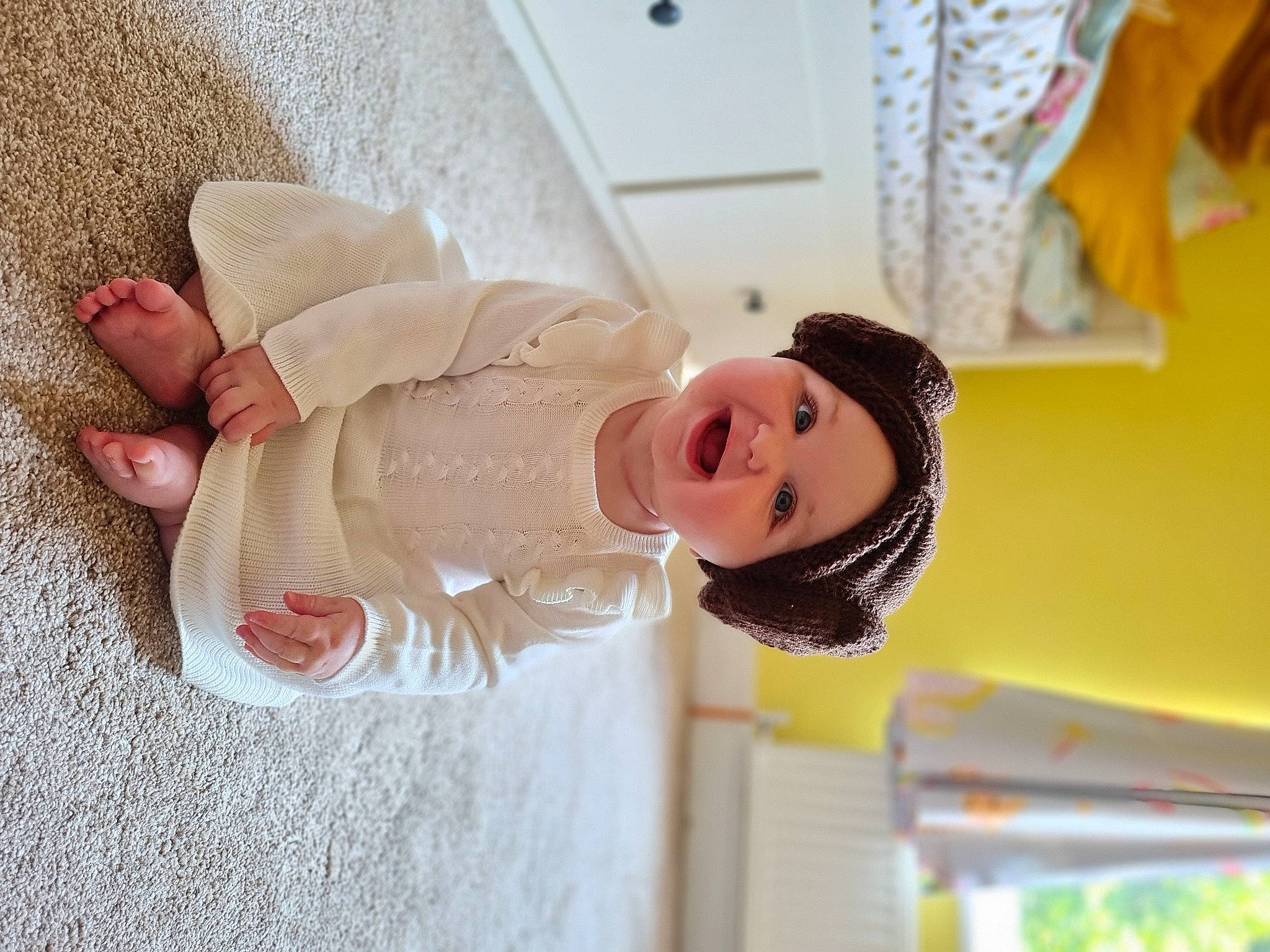 Mabel is registered to the contest to win money with this photo: baby, baby_toddler_clothing, cap, child, event, fashion_accessory, foot, fun, happy, hat, headgear, headwear, leisure, peach, person, room, skin, smile, sun_hat, toddler