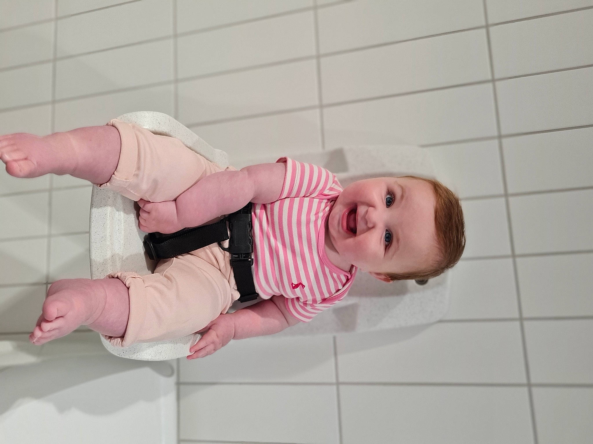 Mabel is registered to the contest to win money with this photo: baby, baby_products, baby_safety, baby_toddler_clothing, cheek, child, comfort, dress, finger, flooring, happy, human_body, leg, person, pink, room, skin, sleeve, smile, sock