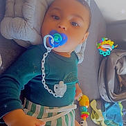 Ngolo participe au concours pour gagner de l'argent avec cette photo : baby, pacifier, toy, blanket, couch, child, infant, clothing, striped_shorts, blue_top, indoor, face, smile, hand, comfort, play, soft_toys, colorful, relaxing, sparkle_effect