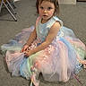 blue, carpet, child, curly_hair, cute, dress_up, floor, furniture, indoor, pastel_colors, pink, playtime, portrait, sitting, storage_box, toy, tutu_dress, unicorn_wand, white, young_girl