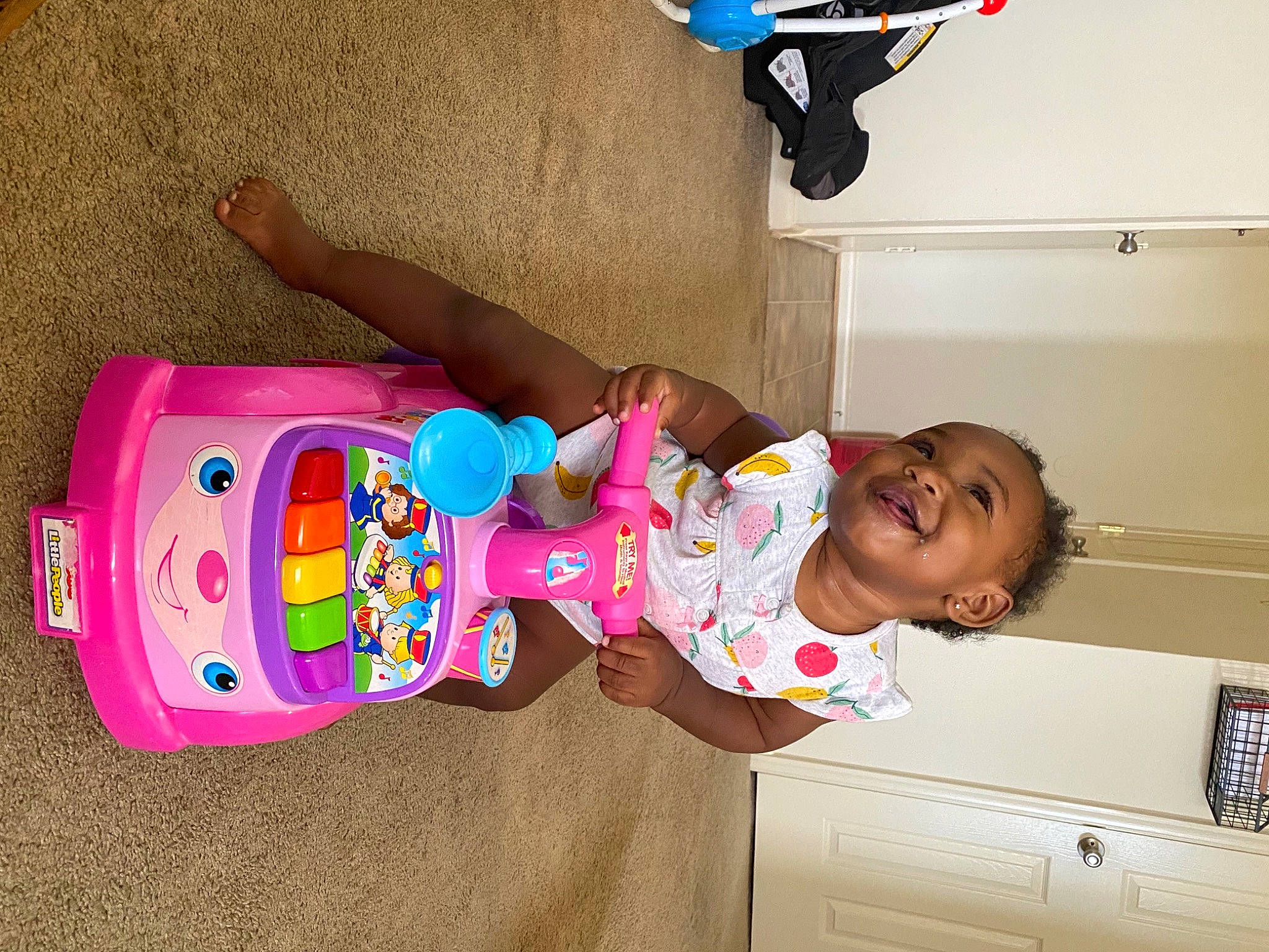 Camille is registered to the contest to win money with this photo: baby, baby_products, baby_toddler_clothing, cabinetry, chest_of_drawers, child, cool, drawer, finger, fun, happy, joy, magenta, person, pink, play, room, sleeve, smile, t_shirt