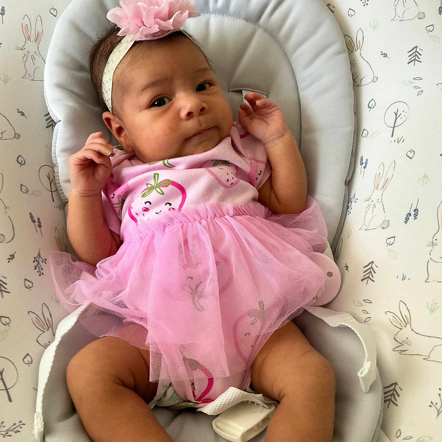 Mariah is registered to the contest to win money with this photo: baby, infant, pink_tutu, headband, flower, baby_seat, bunny_pattern, cute, child, footwear, white_shoes, cushion, indoor, portrait, newborn, clothing, baby_girl, relaxed, expression, small_hands