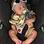 accessory, baby, bib, car_seat, child, clothing, cute, fabric, feet, hands, indoor, infant, pacifier, person, relaxed, safety, seatbelt, sleeping, sunglasses, teddy_bear