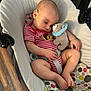 Joni is registered to the contest to win money with this photo: baby, baby_seat, casual, child, comfort, cushion, cute, foot, hand, indoor, infant, onesie, peaceful, plush_toy, resting, sleeping, small_toy, striped_clothing, toddler, wood_floor