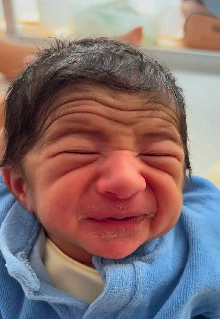 Claude a rejoint le concours — aidez-le/la à gagner de superbes lots ! baby, newborn, face, expression, wrinkled_skin, hair, blue_blanket, closeup, infant, cute, portrait, indoors, person, skin_texture, clothing, young_child, head, small_person, baby_clothes, sleepwear