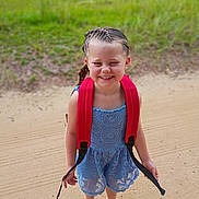 Aymiee joined the competition — help win amazing prizes! child, girl, smiling, braided_hair, red_backpack, blue_dress, lace, sandals, outdoor, grass, sandy_path, happy, standing, summer, daylight, cute, portrait, fashion, nature, feet