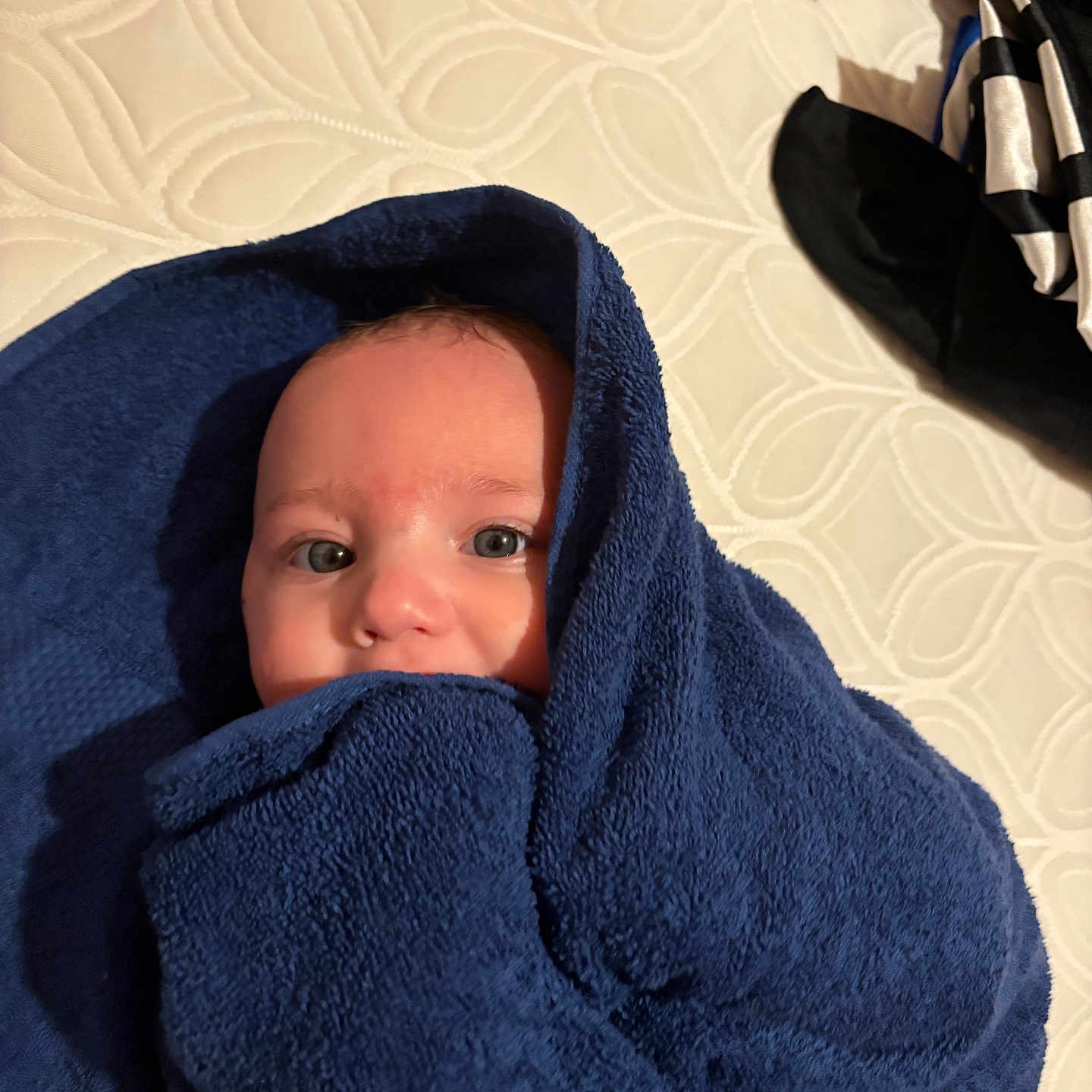 Aric is registered to the contest to win money with this photo: baby, bed, blanket, blue_towel, child, comfort, cozy, cute, eyes, face, head, indoors, infant, mattress, pattern, portrait, skin, soft, towel, wrapped