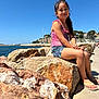 blue_sky, boats, casual_clothing, child, coast, girl, harbor, nature, outdoor, portrait, rocks, sailboats, sea, shoreline, sky, smiling, summer, sunlight, vacation, water