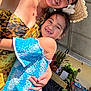 blue, celebration, child, dress, event, family, festival, flower, happy, hat, nature, outdoor, people, plants, portrait, smile, sunlight, tropical, woman, yellow
