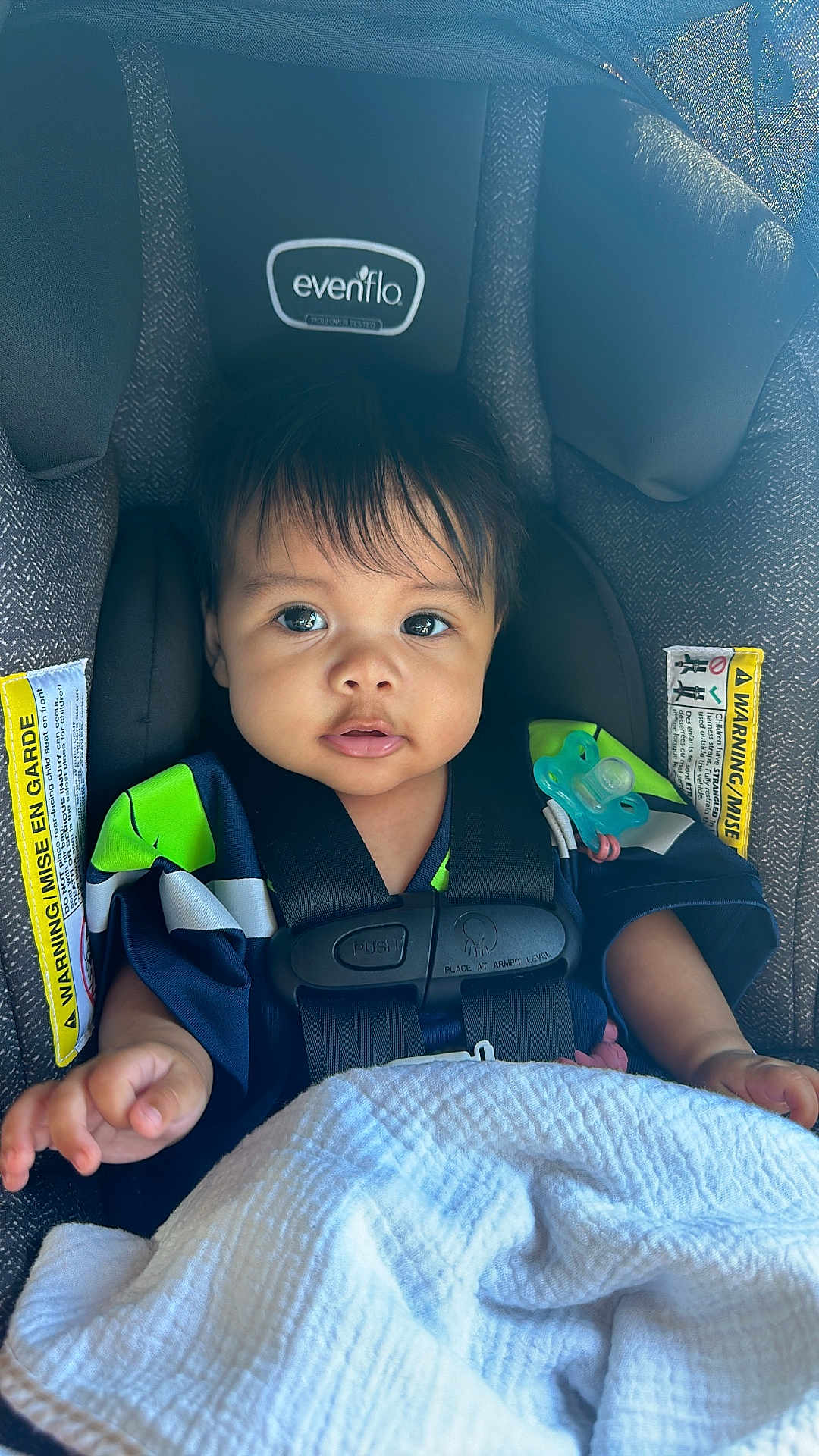Athena joined the competition — help win amazing prizes! baby, child, car_seat, seat_belt, pacifier, blanket, clothing, face, human, infant, sitting, straps, safety, cute, portrait, indoors, young_child, expression, comfort, closeup