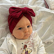 Aria joined the competition — help win amazing prizes! baby, infant, headband, red_bow, white_clothing, winnie_the_pooh, blanket, soft_texture, cute, face, portrait, lying_down, hand, child, indoors, closeup, expression, comfortable, young_child, sleepwear