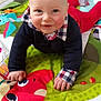baby, child, smiling, crawling, play_mat, colorful, red_fox, navy_sweater, checkered_shirt, floor_tiles, indoor, cute, infant, happy, person, hands, face, blue_eyes, home, wall