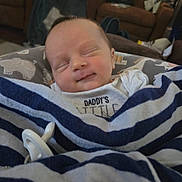 River is registered to the contest to win money with this photo: baby, sleeping, blanket, striped, pacifier, smile, infant, cozy, home, furniture, clothing, cute, peaceful, rest, child, portrait, soft, comfort, newborn, wrapped
