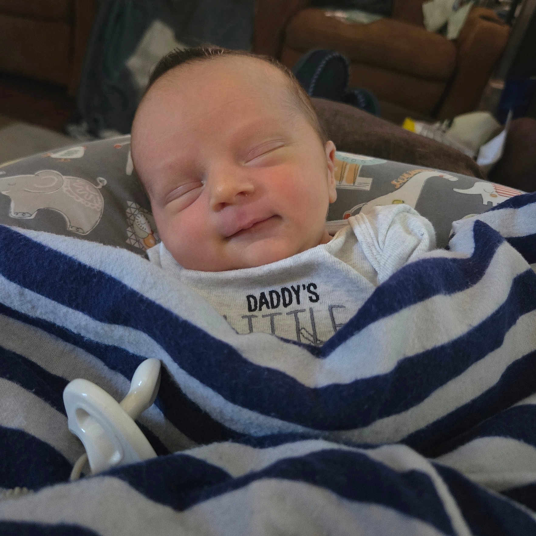 River is registered to the contest to win money with this photo: baby, sleeping, blanket, striped, pacifier, smile, infant, cozy, home, furniture, clothing, cute, peaceful, rest, child, portrait, soft, comfort, newborn, wrapped