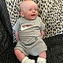 Reggie joined the competition — help win amazing prizes! baby, smiling, sitting, clothing, nike, sneakers, white_shoes, socks, couch, pillow, leopard_print, happy, infant, person, indoor, casual, cute, apparel, fabric, portrait
