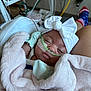 Esmari is registered to the contest to win money with this photo: baby, blanket, bow, child, closeup, headband, healthcare, hospital, indoors, infant, medical_equipment, nasal_cannula, oxygen_tube, person, pink, resting, sleeping, socks, soft_texture, white