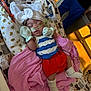 baby, blanket, blue_and_white_top, bow, crib, cute, headband, healthcare, hospital, indoors, infant, medical_tubes, mittens, pacifier, patterned_sheet, person, red_shorts, rest, sleeping, socks