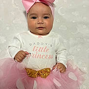 Briana joined the competition — help win amazing prizes! baby, child, pink_bow, tutu_skirt, white_blanket, stars, moons, cute, smile, portrait, infant, dress, headband, seated, soft_texture, adorable, clothing, hands, face, happy