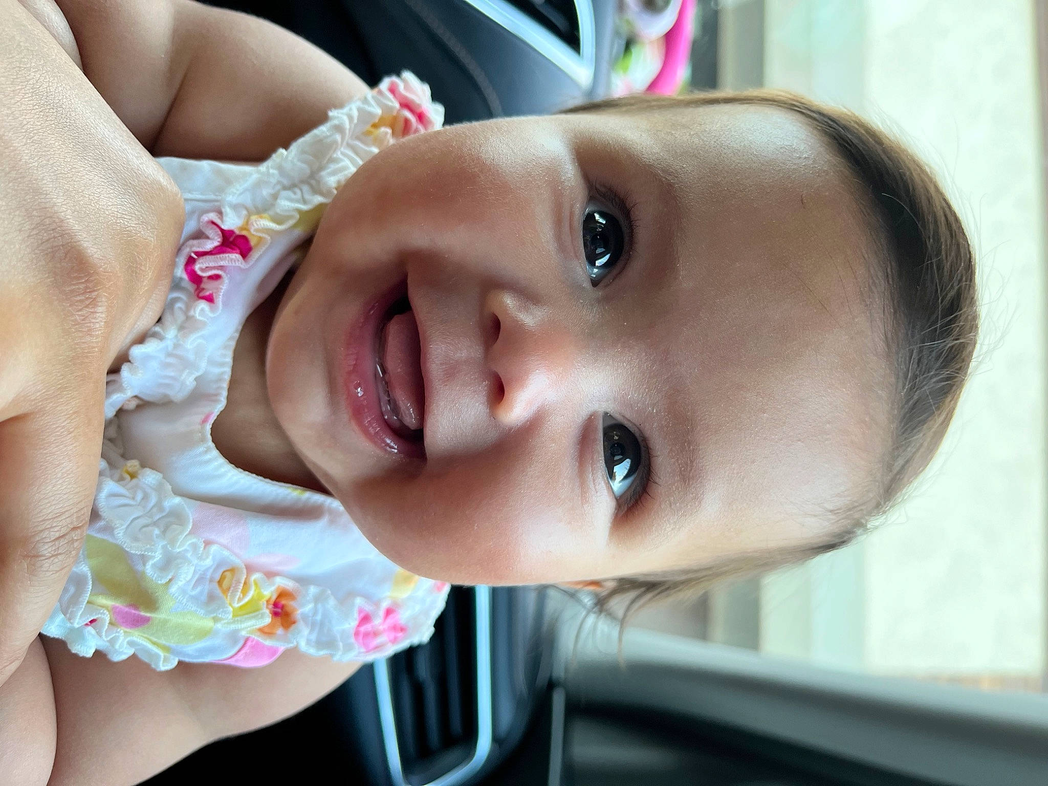 Scarlett is registered to the contest to win money with this photo: baby, baby_toddler_clothing, cheek, child, close_up, dress, eyelash, fun, happy, iris, lip, mouth, neck, nose, person, plant, skin, smile, toddler, tree